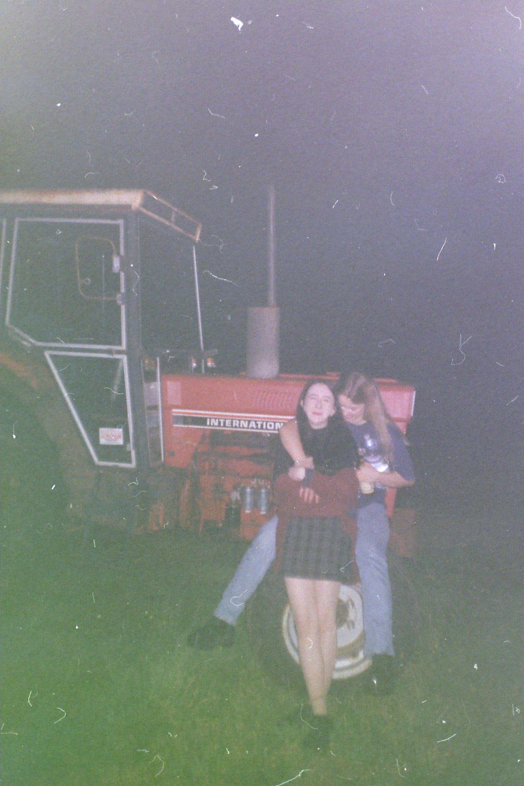 two people leaning against a tractor